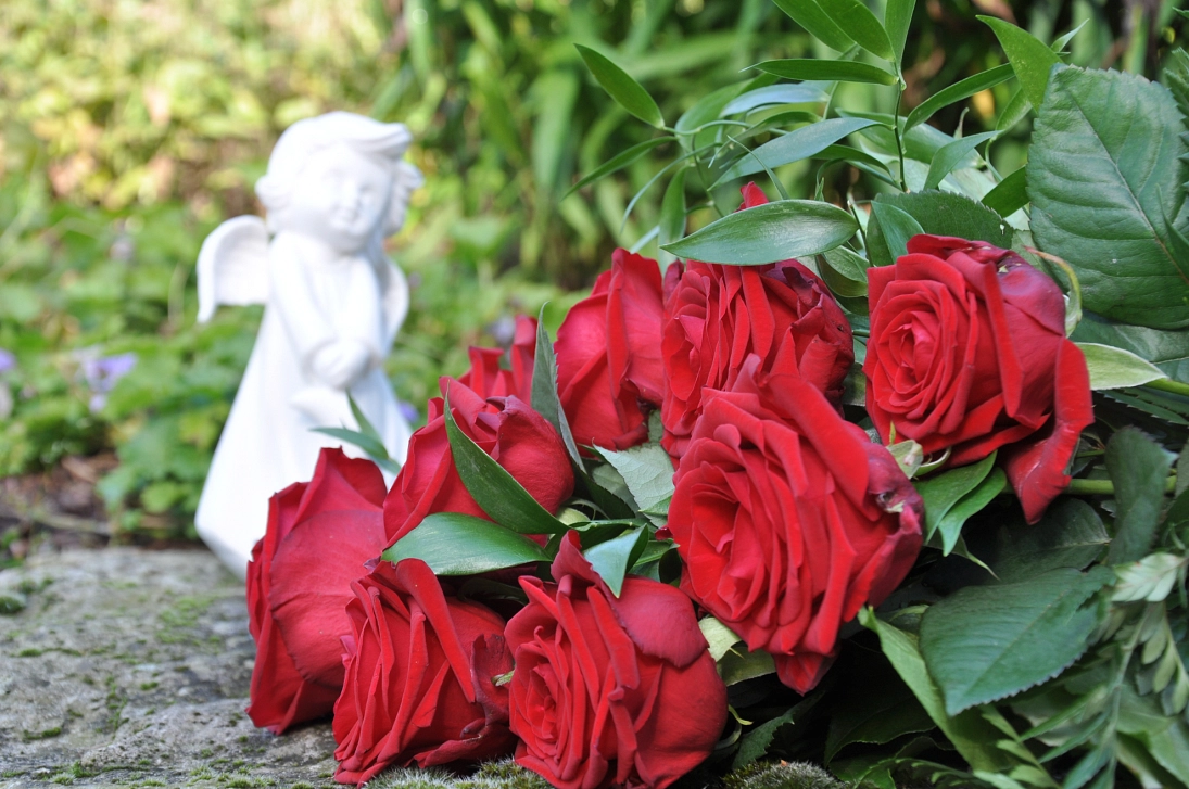 Grabschmuck weißer Engel und rote Rosen